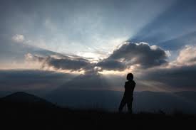 images (3) Imagem de uma mulher de pé em frente a uma montanha, com o sol nascendo ao fundo — simbolizando força, esperança e recomeço.