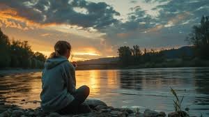 images (4) Uma mulher sentada sozinha perto de um lago ou montanha ao entardecer, com expressão de paz e serenidade. Tons suaves (azul, lilás, dourado). A paisagem deve transmitir calma, silêncio e presença de Deus — sem frases nem textos na imagem.