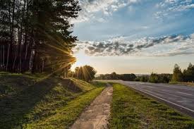 images (80) Uma estrada ao nascer do sol, com névoa leve e montanhas ao fundo, simbolizando esperança e direção — sem texto.