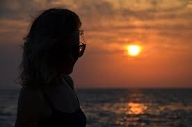 download (11) Pessoa olhando o mar ao pôr do sol em atitude de descanso