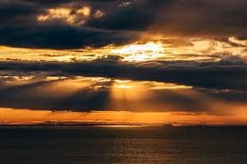 download (7) raios de sol nascendo sobre o horizonte após uma noite escura.