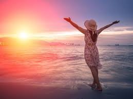 download (2) Pessoa de pé à beira do mar ao amanhecer com os braços erguidos em confiança