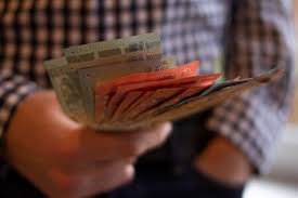 download Pessoa segurando uma carteira aberta com luz incidindo sobre moedas e notas