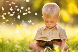 download (7) crianças sorrindo com uma Bíblia infantil colorida nas mãos, sentadas em roda ao ar livre”.