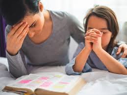 images (1) Mãe cristã orando com o bebê no colo, simbolizando fé e maternidade equilibradas