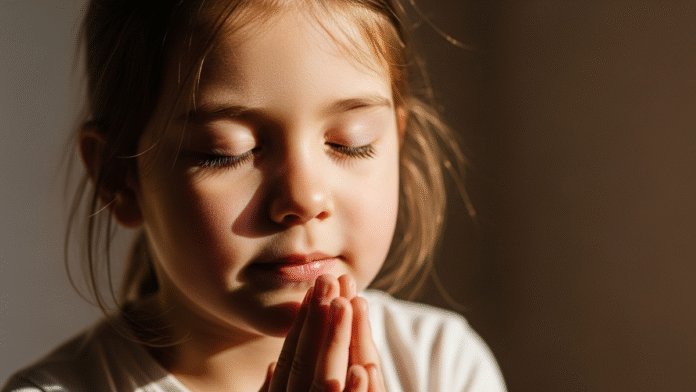 Criança Orando em Gratidão Criança orando com as mãos unidas e olhos fechados em atitude de gratidão.