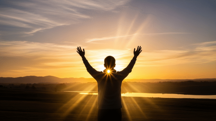 Pessoa com Mãos Erguidas ao Amanhecer (2) Pessoa com as mãos erguidas ao amanhecer, representando a graça restauradora de Deus.