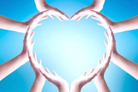 download imagem simbólica de mãos abertas segurando um coração iluminado, representando entrega e cuidado.