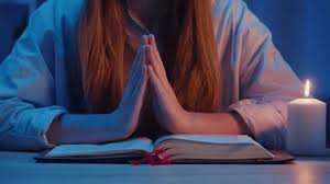 download (24) Mulher em postura de oração silenciosa com iluminação suave, representando descanso em Deus.