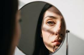 download (5) Pessoa em silêncio diante de um espelho, com luz suave simbolizando restauração da identidade.