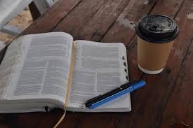 download (8) Bíblia aberta e xícara de café em uma mesa, representando um momento de devocional diário simples.